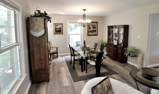 dining space featuring light wood-type flooring and an inviting chandelier