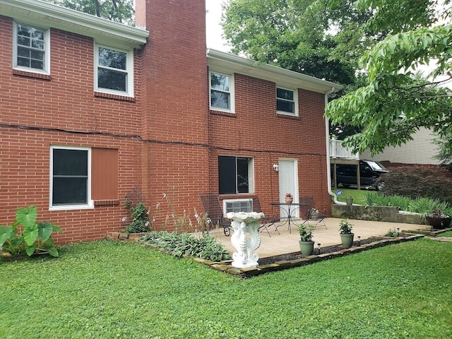 back of property featuring a patio and a yard