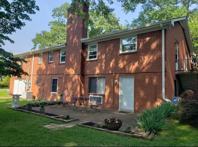 back of house with a lawn, central air condition unit, and a patio area