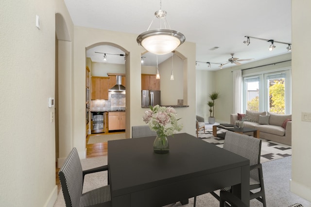 dining space featuring light carpet, beverage cooler, and ceiling fan