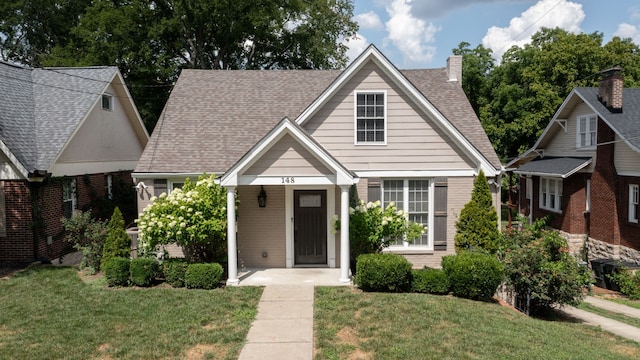 view of front of property featuring covered porch and a front yard