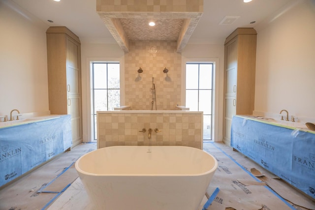 bathroom with tile walls, a bathing tub, and a healthy amount of sunlight