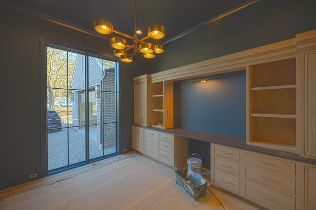 unfurnished office featuring built in desk and a chandelier