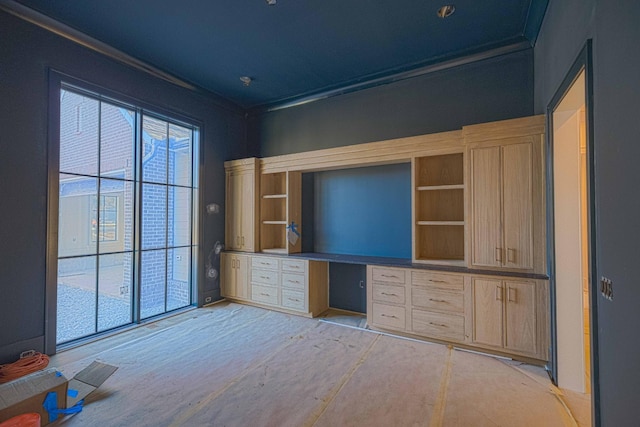 unfurnished office featuring crown molding and built in desk