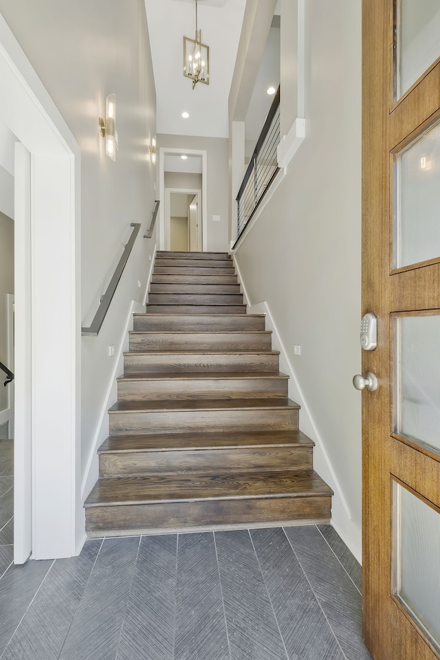 stairway with tile patterned flooring and a chandelier