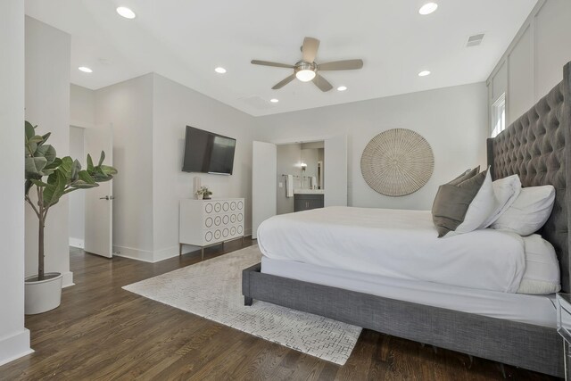 bedroom with ceiling fan, connected bathroom, and dark hardwood / wood-style flooring