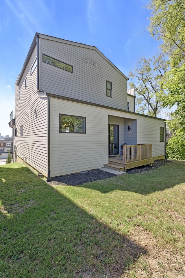 rear view of house with a lawn and a deck