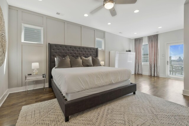 bedroom featuring ceiling fan, multiple windows, and dark hardwood / wood-style flooring