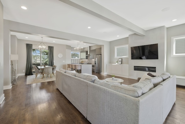 living room with wood-type flooring, beamed ceiling, and a notable chandelier