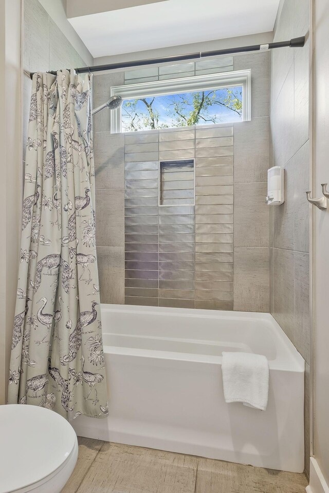 bathroom with toilet and shower / tub combo with curtain