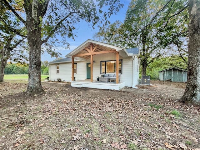 view of front of house featuring a shed, a porch, and central air condition unit