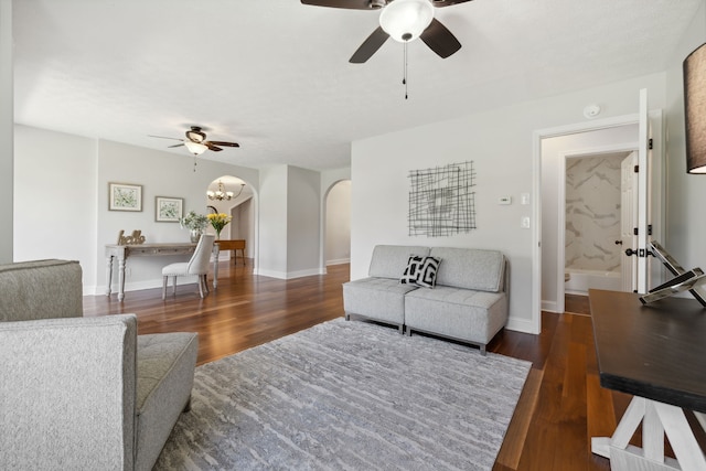 living room with ceiling fan and dark hardwood / wood-style flooring