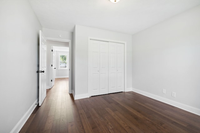 unfurnished bedroom featuring a closet and dark hardwood / wood-style flooring