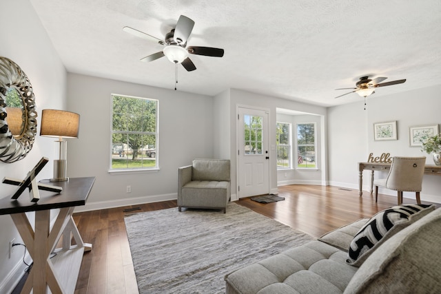 living room with ceiling fan, dark wood-type flooring, and plenty of natural light