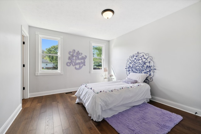 bedroom with dark hardwood / wood-style floors