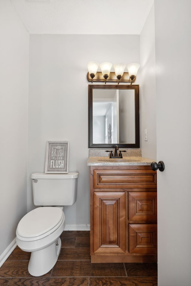 bathroom with wood-type flooring, vanity, and toilet