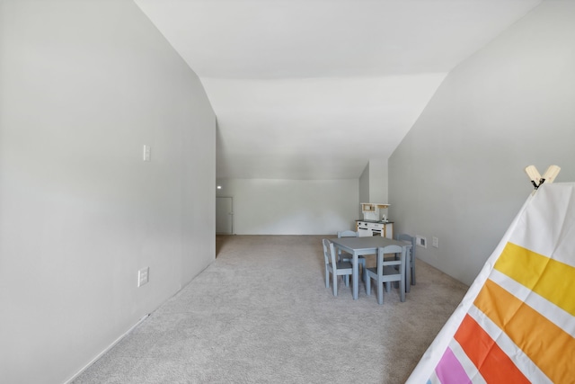 interior space with carpet flooring and vaulted ceiling