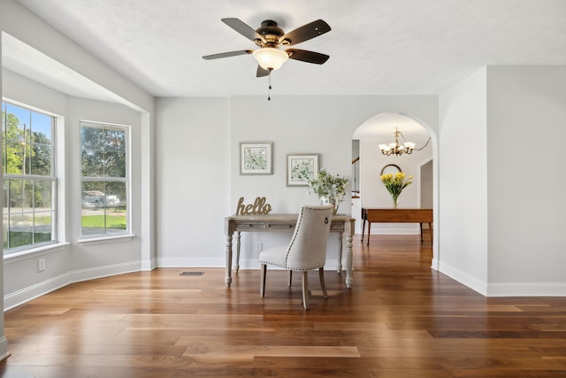 dining space with ceiling fan with notable chandelier, a textured ceiling, and dark hardwood / wood-style flooring