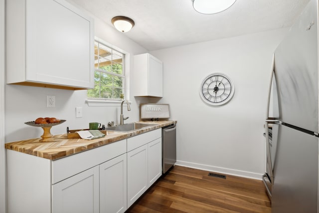 kitchen featuring sink, wooden counters, white cabinetry, stainless steel appliances, and dark hardwood / wood-style floors