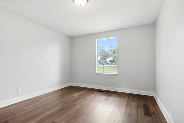 unfurnished room featuring dark wood-type flooring