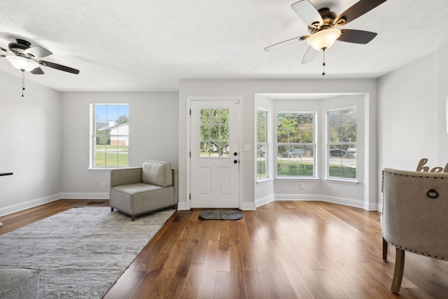 sitting room with a textured ceiling, hardwood / wood-style flooring, and ceiling fan