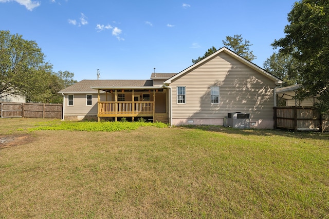 rear view of house featuring a lawn and a deck