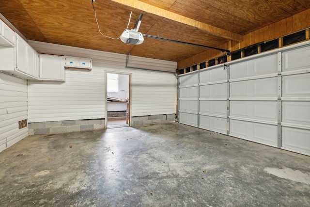 garage featuring a garage door opener and wooden ceiling