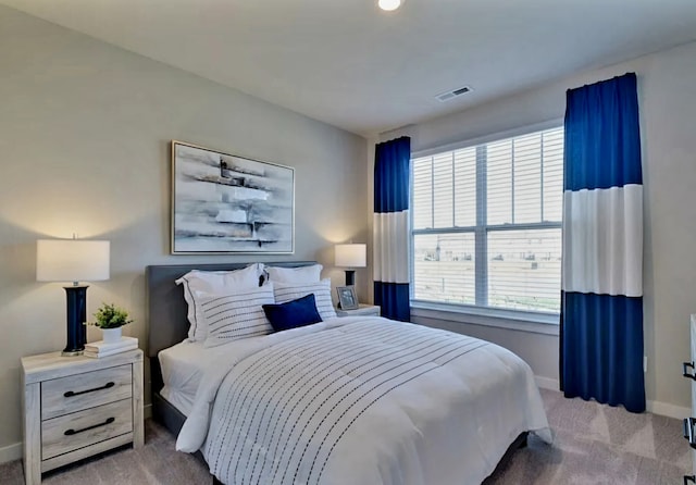 bedroom featuring light carpet and multiple windows