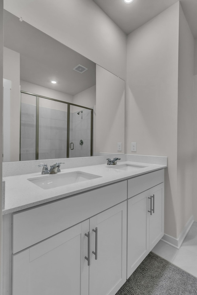 bathroom with tile patterned flooring, vanity, and a shower with shower door