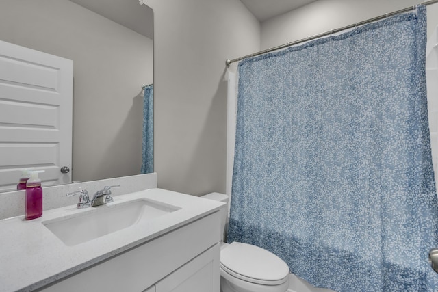 bathroom with walk in shower, vanity, and toilet