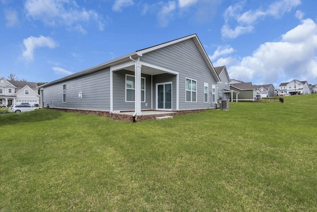 back of property featuring a yard, central AC, and a patio area