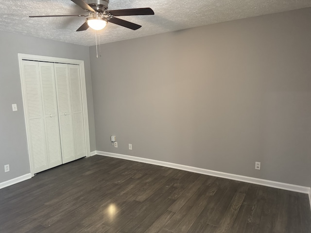 unfurnished room featuring ceiling fan, dark wood-type flooring, and a textured ceiling