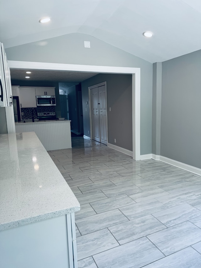 interior space with light hardwood / wood-style flooring and vaulted ceiling