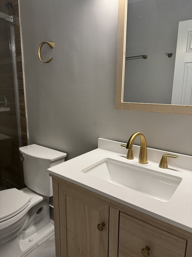 bathroom featuring vanity, toilet, and a shower with door