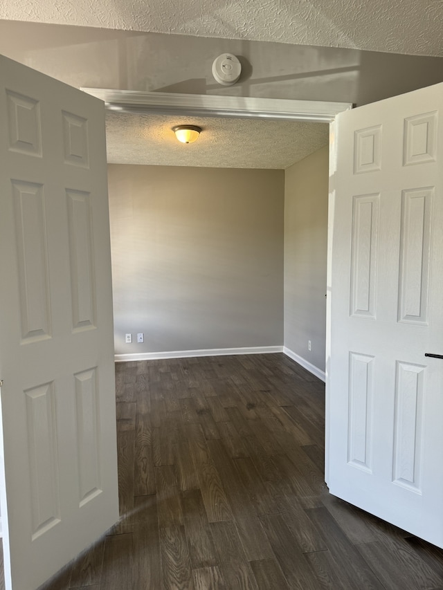 unfurnished room featuring a textured ceiling and dark hardwood / wood-style floors