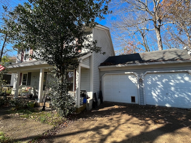 view of property exterior featuring a porch and a garage