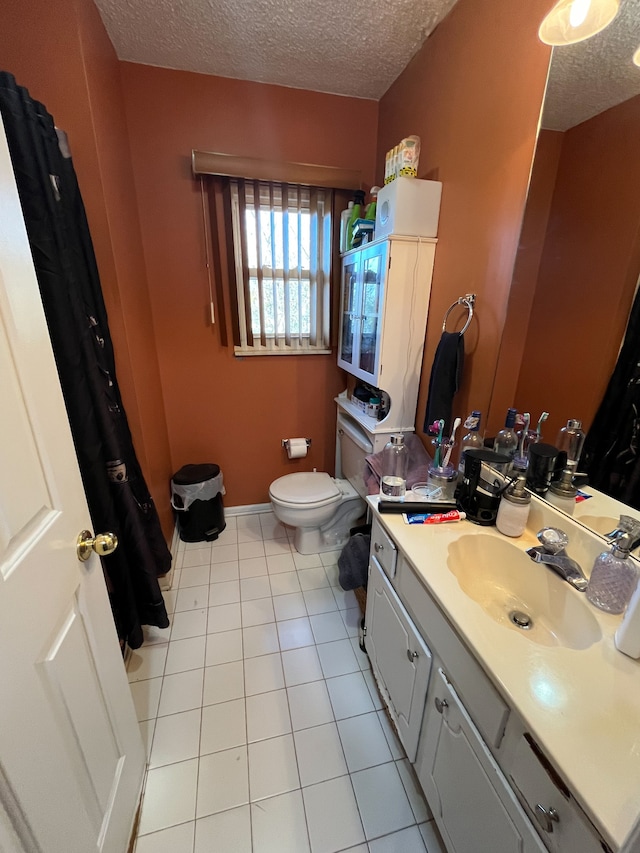 bathroom with tile patterned floors, toilet, a textured ceiling, and vanity