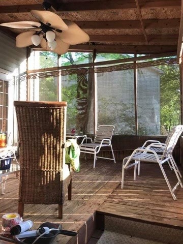 unfurnished sunroom with ceiling fan