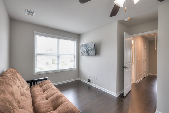 living area with ceiling fan and dark hardwood / wood-style flooring