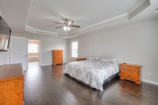 bedroom featuring dark wood-type flooring, crown molding, a tray ceiling, ceiling fan, and ensuite bathroom