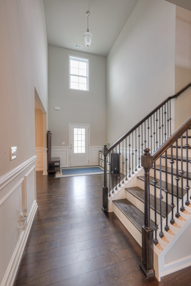 entrance foyer featuring a towering ceiling and dark hardwood / wood-style flooring