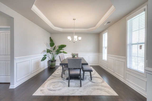 dining room featuring a notable chandelier, a tray ceiling, dark wood-type flooring, and crown molding