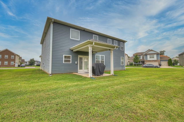 rear view of property featuring a lawn and a garage