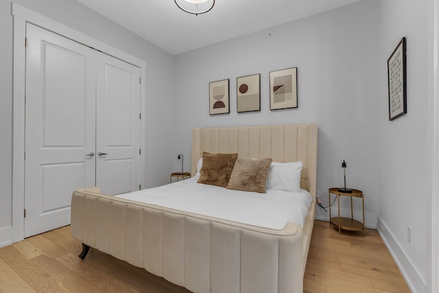 bedroom with light wood-type flooring and a closet