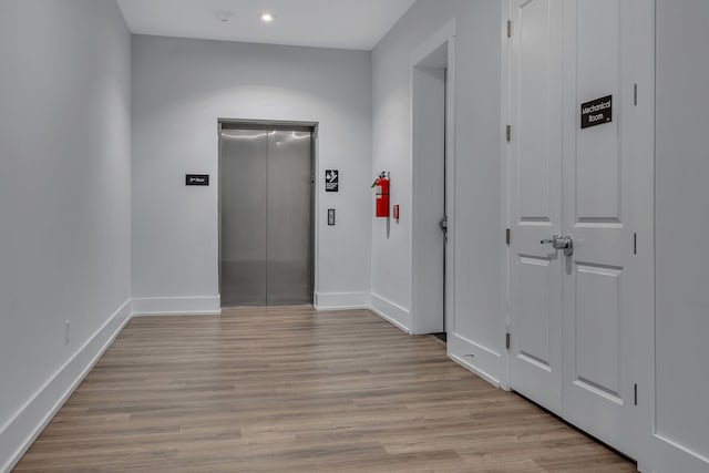 hall featuring light hardwood / wood-style flooring and elevator