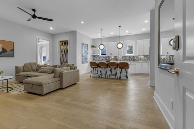 living room featuring ceiling fan and light hardwood / wood-style flooring