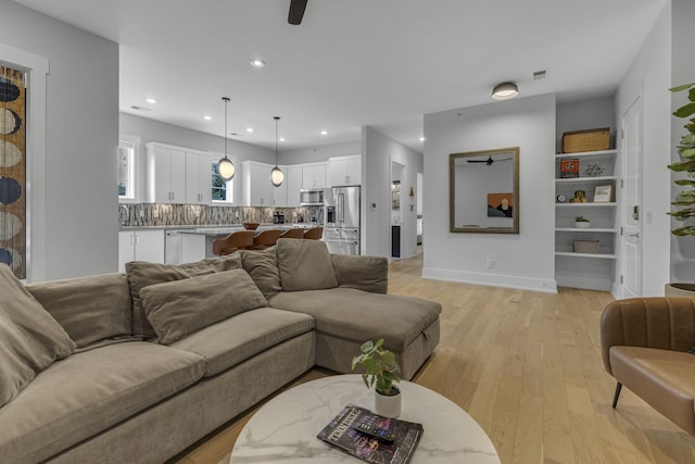 living room featuring light hardwood / wood-style floors and ceiling fan