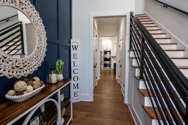 hallway with ornamental molding and dark wood-type flooring