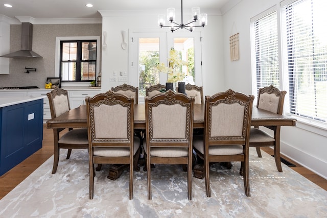 dining area featuring ornamental molding, a chandelier, and light hardwood / wood-style flooring