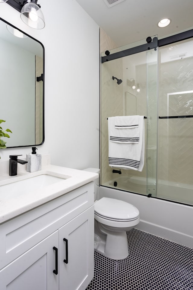 full bathroom featuring enclosed tub / shower combo, tile patterned flooring, vanity, and toilet